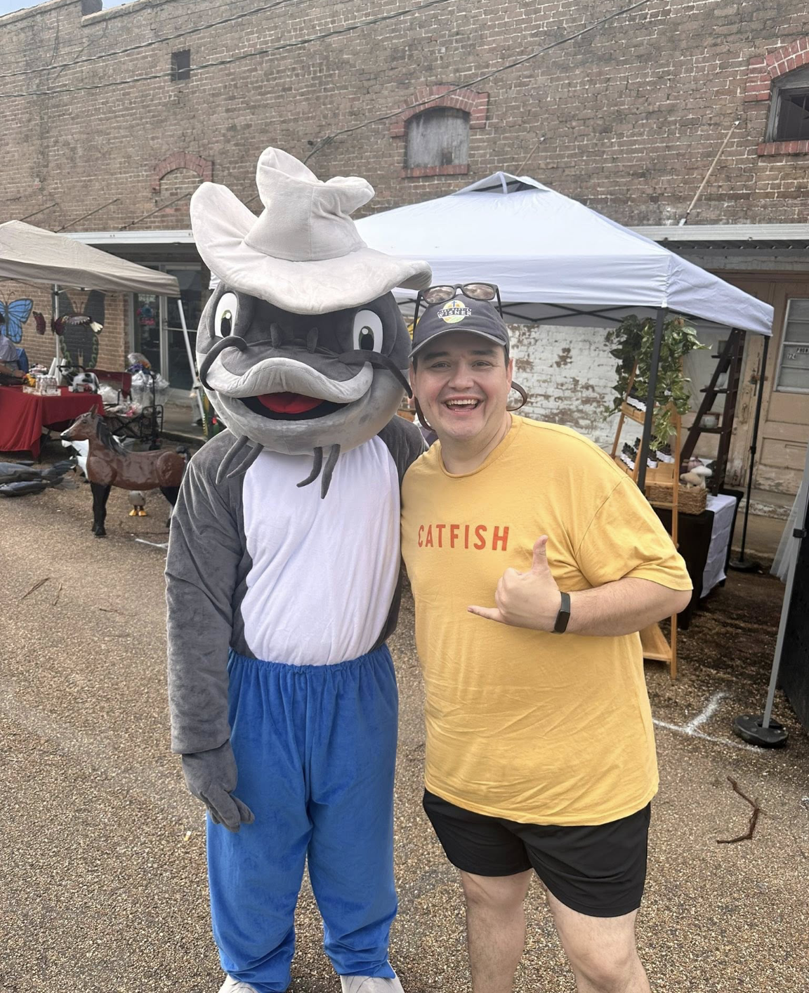 Fan in a Catfish shirt posing with the mascot